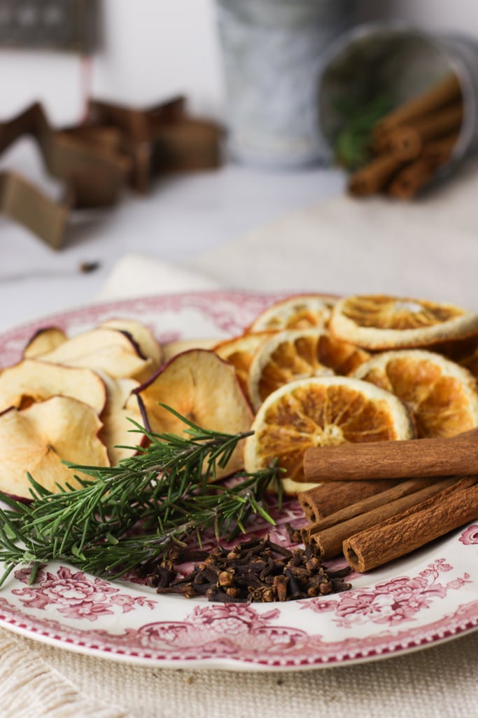 decorative plate holding dried fruit, rosemary, clove and cinnamon sticks 