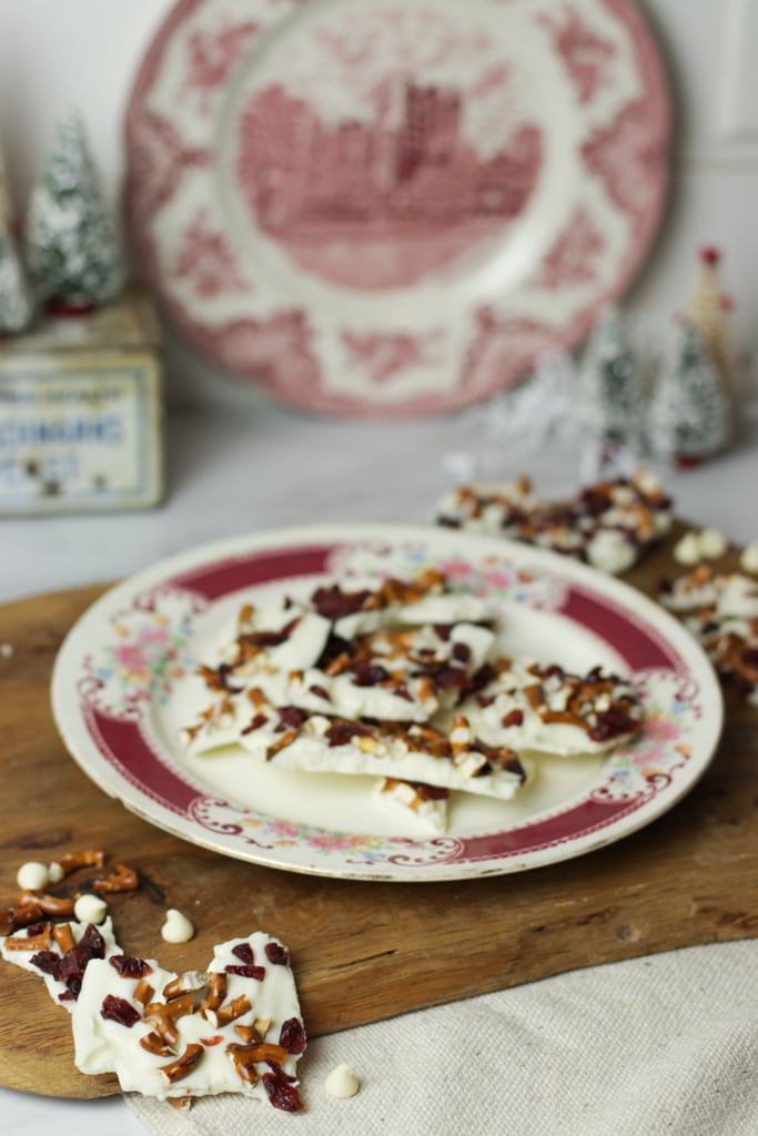pieces of white chocolate cranberry bark with pretzels on a pretty china plate